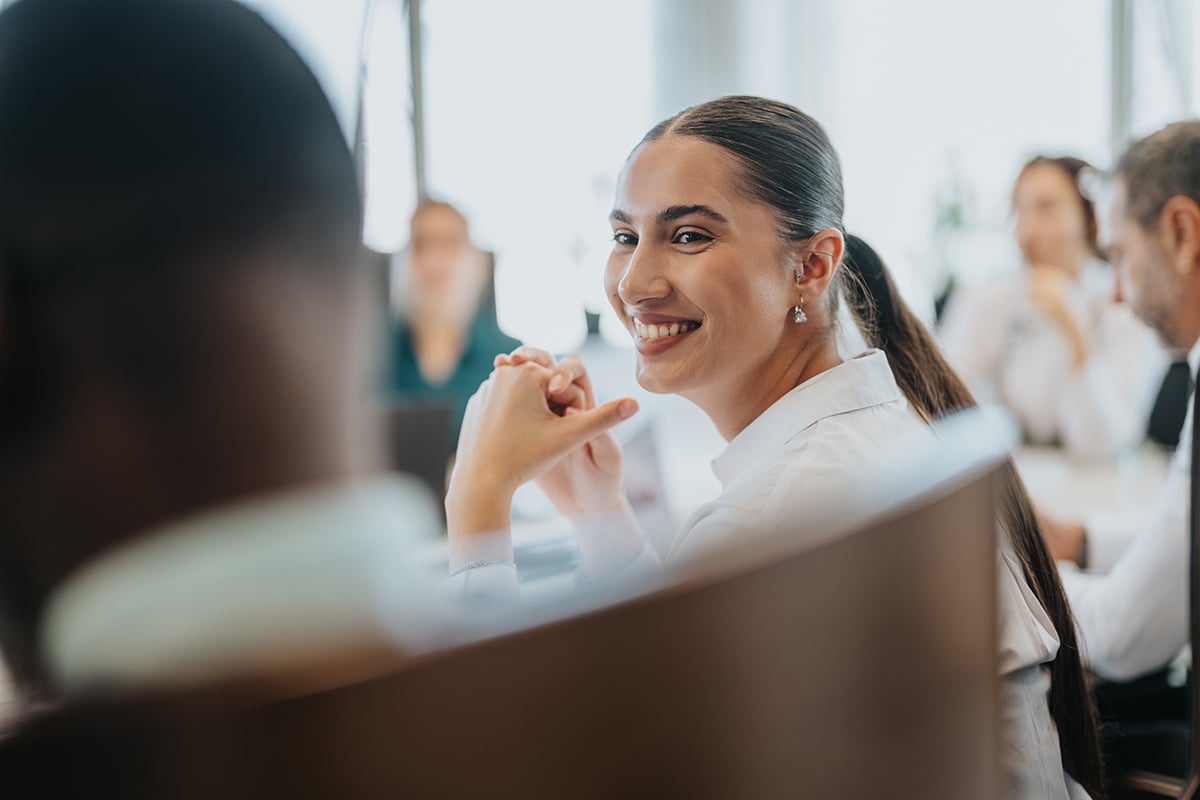 Young woman smiling in a collaboartive work environment