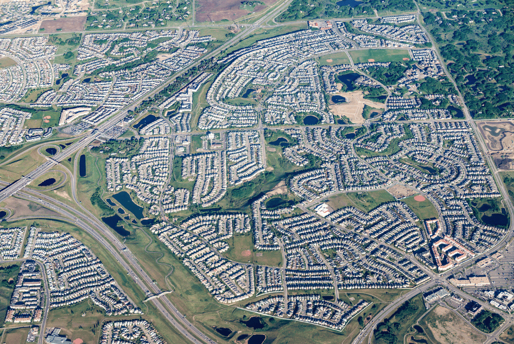 Aerial view of a suburban residential area with roads, homes, parks, and stormwater ponds.