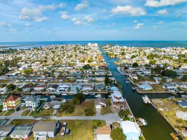 Aerial view of a waterfront residential community in Pasco County with canals, homes, and boatsy in Pasco County with canals, homes, and boats