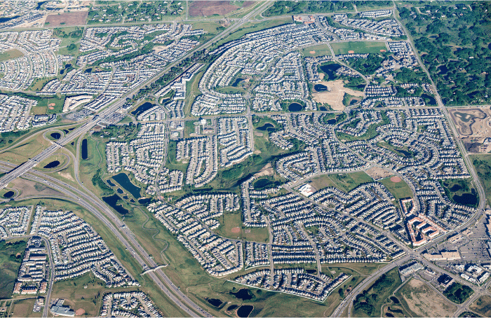Aerial view of a suburban residential area with roads, homes, parks, and stormwater ponds.