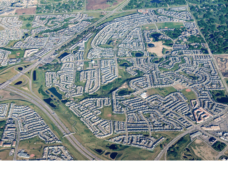 Aerial view of a suburban residential area with roads, homes, parks, and stormwater ponds.