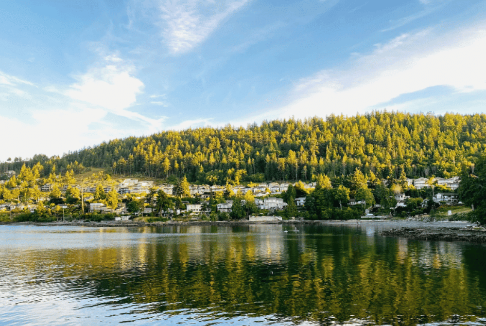 Waterfront neighborhood in Nanaimo, British Columbia, with homes on a forested hillside overlooking calm water.