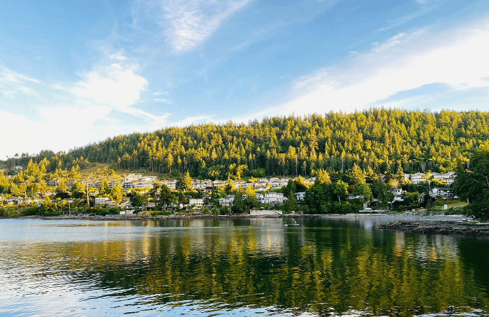 Waterfront neighborhood in Nanaimo, British Columbia, with homes on a forested hillside overlooking calm water.