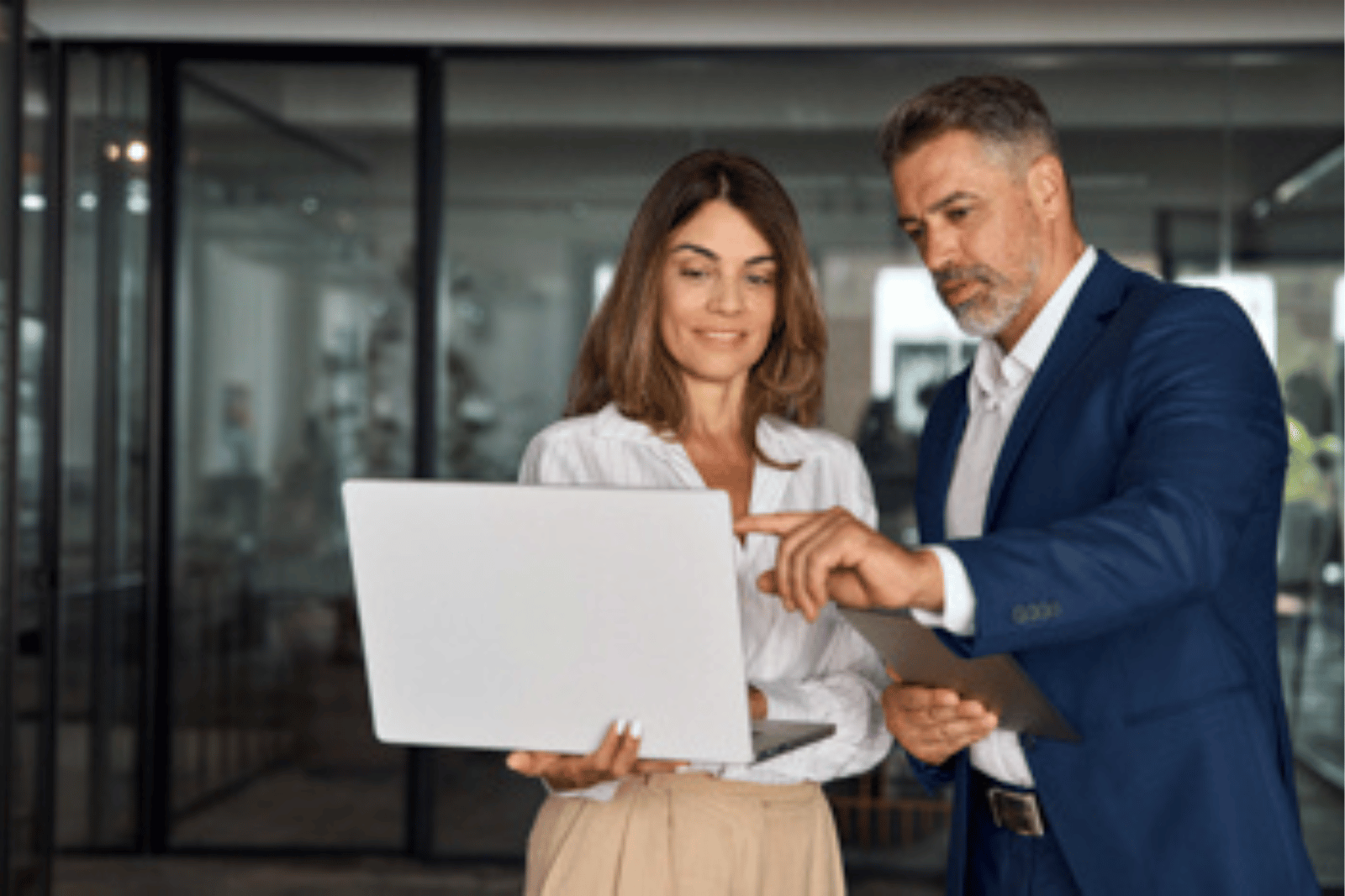 Professionals reviewing information on a laptop representing strategic partnerships and collaborative solutions