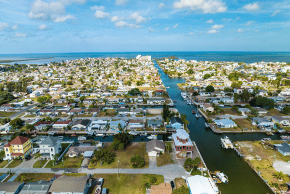 Aerial view of a waterfront residential community in Pasco County with canals, homes, and boats
