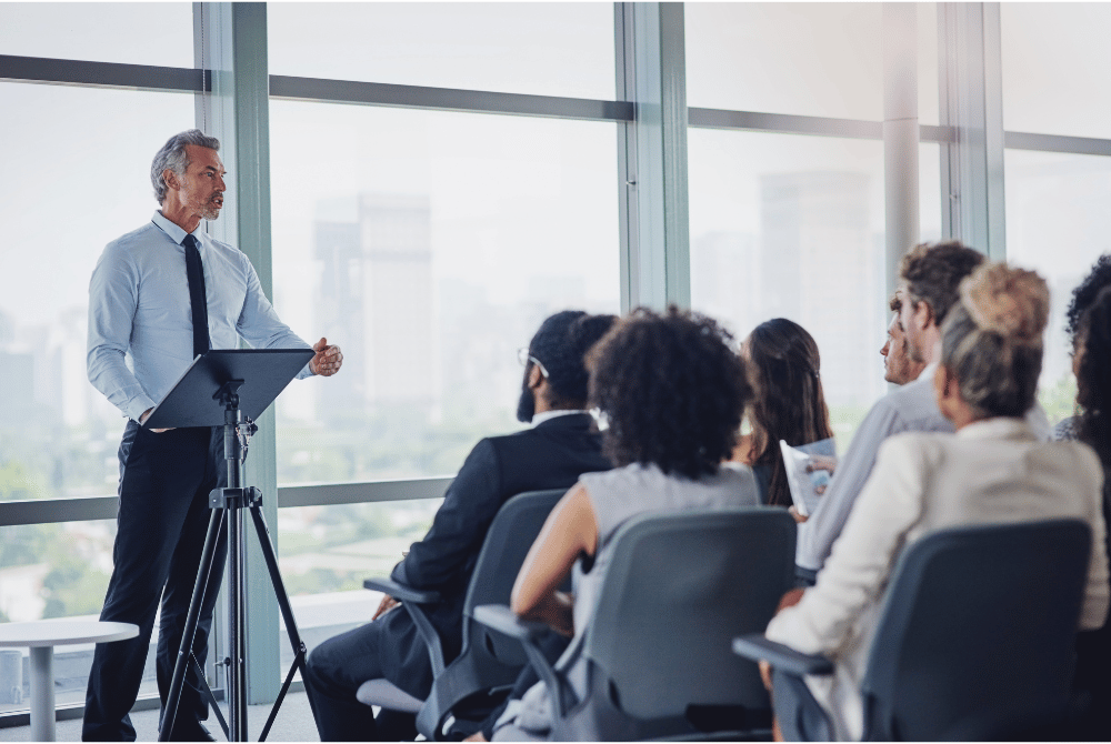 Business presentation with a speaker standing at a lectern before an audience