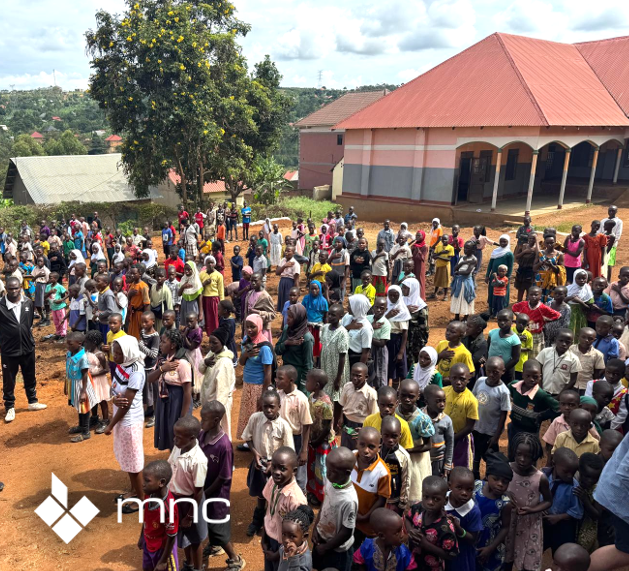 Students and teachers gathered outside a school supported through the Classrooms for Africa initiative.