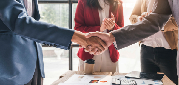 Professionals shaking hands representing trusted partnerships in land data modernization projects